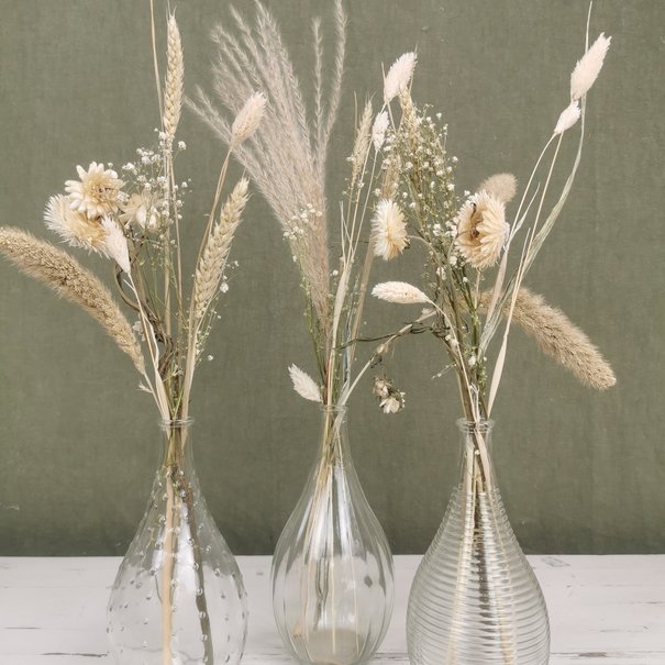 Three vases filled with natural-coloured dried flowers 